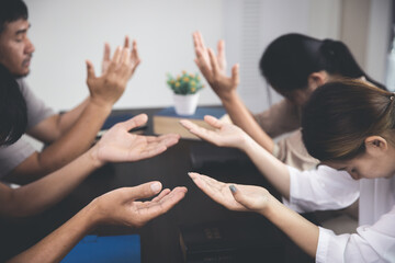 Sticker - Group of religious people praying together indoors. group of people holding hands and praying while sitting in office.