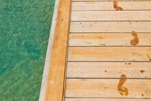 Wet Footprints Track On Wooden Pier Next To Sea, West End, Roatan, Honduras