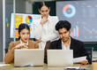 © Bangkok Click Studio - Millennial Asian Indian professional multinational male businessmen and female businesswomen in formal business suit standing sitting in meeting room mentoring brainstorming together with laptop