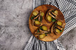 Sandwiches with sprats, herbs and pickles on a round cutting wooden board on a dark grey background. Top view, flat lay