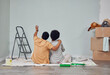 Planning, wall or black couple pointing in home renovation, diy or house remodel together on floor. Back view, painting or African man loves talking or working with teamwork in decoration with woman
