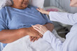 © Seventyfour - Close up of caring young nurse supporting female patient in hospital bed