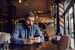 © Dusan Petkovic - A surprised young man is sitting in coffee shop and looking at the phone.
