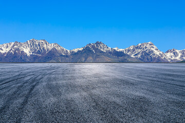 Wall Mural - Empty asphalt road and snow mountain natural landscape under blue sky