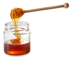 Wall Mural - Honey dripping from wooden honey dipper in glass jar