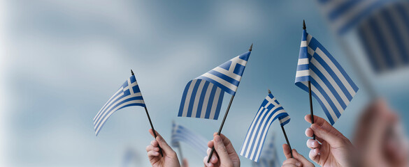 A group of people holding small flags of the Greece in their hands