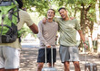 © T Mdlungu/peopleimages.com - Travel, friends and photography in park for holiday, adventure and journey, happy and bond. Smile, men and travelling influencer hug for blog, profile picture or live streaming for online followers