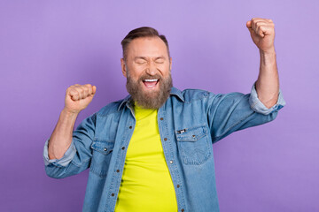 Portrait of astonished glad person closed eyes raise fists scream yeah isolated on purple color background