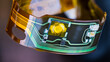 © KPixMining - Flex printed circuit and small electronic components in plastic strip curled into circle on dark background. Closeup of ribbon cable with green and yellow copper lines on flexible PCB from headphones.