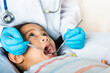 © sorapop - Dental kid health examination. Asian dentist making examination procedure for cute little girl open mouth, Doctor examines oral cavity of little child uses mouth mirror to checking teeth cavity