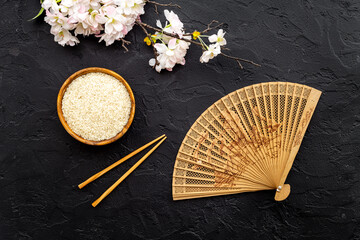 Wall Mural - Chinese or Japanese background with bowl of rice and fan, top view