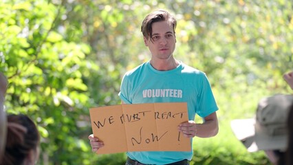 Positive male active caucasian people holding an environment and ecology poster and giving a rousing speech at a volunteer camp