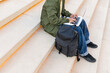 © ADDICTIVE STOCK - Anonymous student with backpack using laptop on stairs