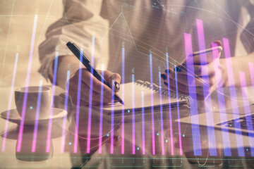 Wall Mural - Double exposure of financial graph sketch hologram and woman holding and using a mobile device. Stock exchange concept.