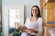 © BullRun - Cheerful young woman spending weekend at home with book