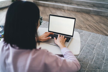 Wall Mural - Female freelancer browsing laptop with empty screen