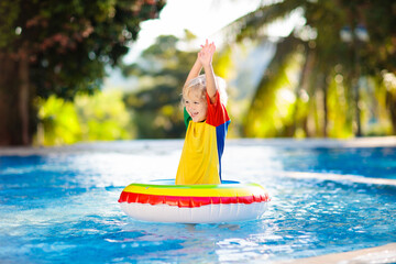 Canvas Print - Child in swimming pool on toy ring. Kids swim.