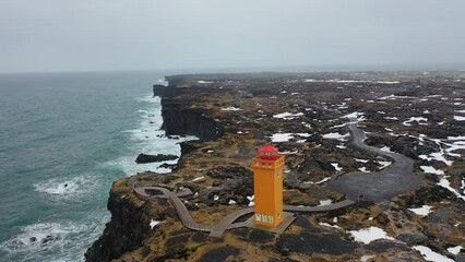 Wall Mural - 4K aerial footage in the north of Iceland around the orange lighthouse called Svörtuloft. Great coastal landscape in winter.