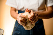 © fesenko - Selective focus on female hands and fingers which masterfully and vigorously knead raw bread dough