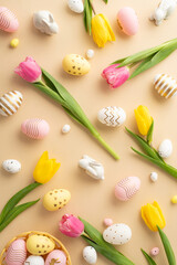 Wall Mural - Easter concept. Top view vertical photo of colorful easter eggs in bowl ceramic easter bunnies yellow and pink tulips on isolated light beige background