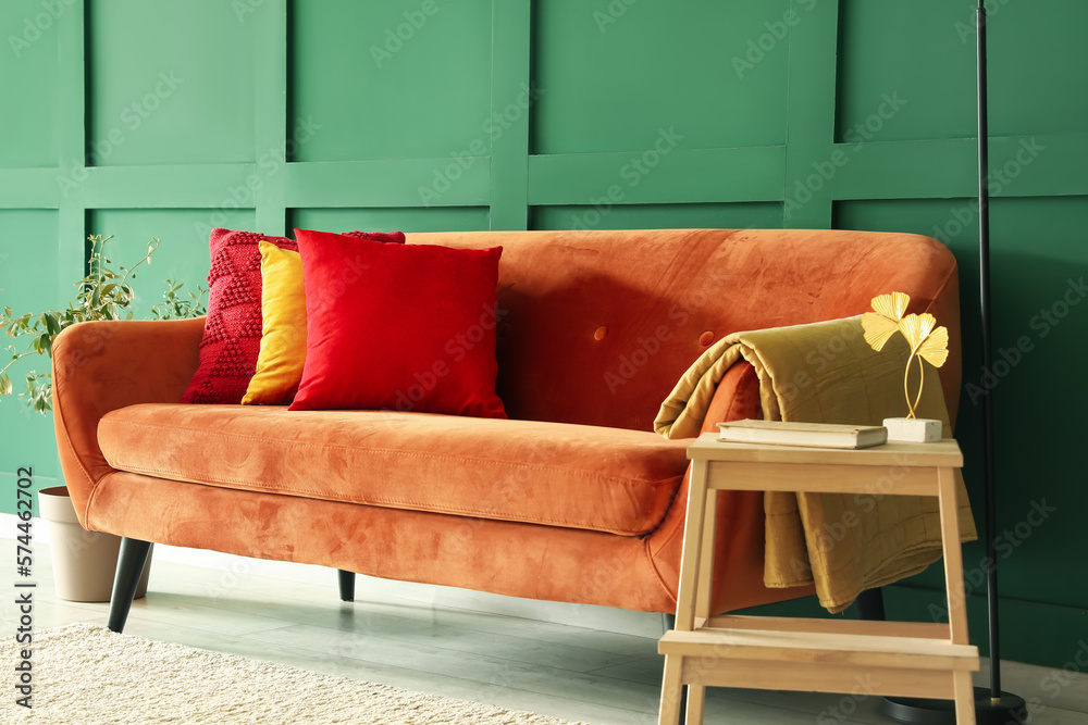 Red sofa with stylish cushions in living room
