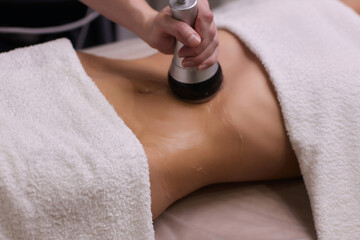 procedure removing cellulite on female abdomen, cavitation belly massage. ultrasonic massage for wei