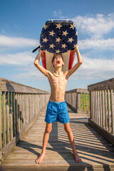 Wall Mural - Youth Child Preteen Boy Standing on Beach Holding A Boogie Board Over His Head