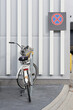 angeschlossenes Fahrrad an einem Supermarkt, dahinter ein Halteverbotdschild an der Wand
