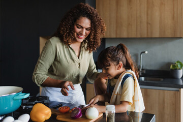 Wall Mural - Hispanic mother and child daughter cooking at kitchen in Mexico Latin America