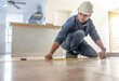 © Lumeez/peopleimages.com - Man, carpenter and measure floor with tape, home interior and buildings maintenance. Builder, construction and handyman measuring flooring on ground, wood board house and property renovation tools