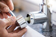 © Lumeez/peopleimages.com - Plumber, hands and faucet, plumbing and maintenance with man, manual labour closeup and home renovation. Construction trade, handyman with kitchen or bathroom sink with hardware, pipe and DIY