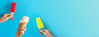 Kids hands holding cups with different ice cream and red-yellow popsicle on bright blue background.