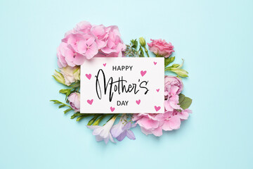 Wall Mural - Happy Mother's Day greeting card and beautiful flowers on pale light blue background, flat lay