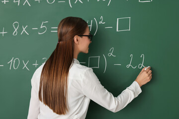 Wall Mural - Young math’s teacher writing mathematical equations near chalkboard