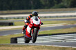 a motorcycle rider on a red and white sport motorcycle riding on the road at high speed