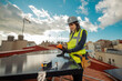 © BASILICOSTUDIO STOCK - Female electrician engineer using Multimeter on domestic urban Solar Panels
