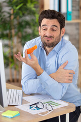 Wall Mural - office worker disgusted face holding a carrot