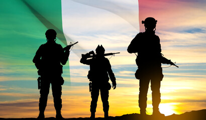 Wall Mural - Silhouettes of a soldiers with Italian flag on sunset background. EPS10 vector