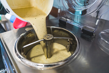 pouring ice cream mix into a pasteurizing machine. high quality photo