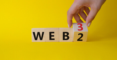 Web 3 vs Web 2 symbol. Businessman Hand turns cubes and changes the word web 2 to web 3. Beautiful yellow background. Business concept. Copy space