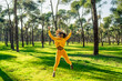 © Aydan - A girl in a yellow tracksuit jumping for joy in the park.