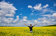 © Ryzhkov Oleksandr - Man with arms outstretched. Handsome young man standing in a field of blooming yellow rapeseed flowers.