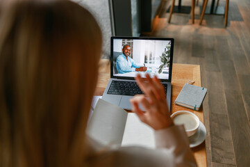 Wall Mural - Close up of businesswoman via videoconference discuss project with colleague use sign language 