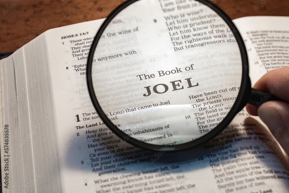 title page book of joel close up using magnifying glass in the bible or ...