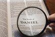 title page book of Daniel close up using magnifying glass in the bible or Torah for faith, christian, hebrew, israelite, history, religion, christianity, Old Testament