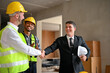 © bongkarn - Cheerful Caucasian businessman is shaking hands with an engineer manager while inspecting