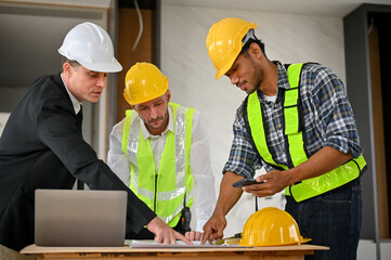 Asian male foreman is talking and planning building process with a Caucasian businessman