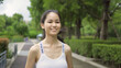© tampatra - Portrait of Asian woman girl in yoga class club doing exercise, runing or jogging at public garden park. Outdoor sport and recreation. People lifestyle activity with nature trees view.