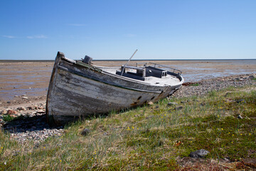Naklejka na meble Front view of old wooden boat wrecked and stranded on a rocky shoreline, north of Arviat, Nunavut, Canada
