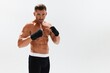 © SHOTPRIME STUDIO - Man athletic bodybuilder poses in boxing gloves with nude torso abs in full-length background, boxing and martial arts. Advertising, sports, active lifestyle, competition, challenge concept.